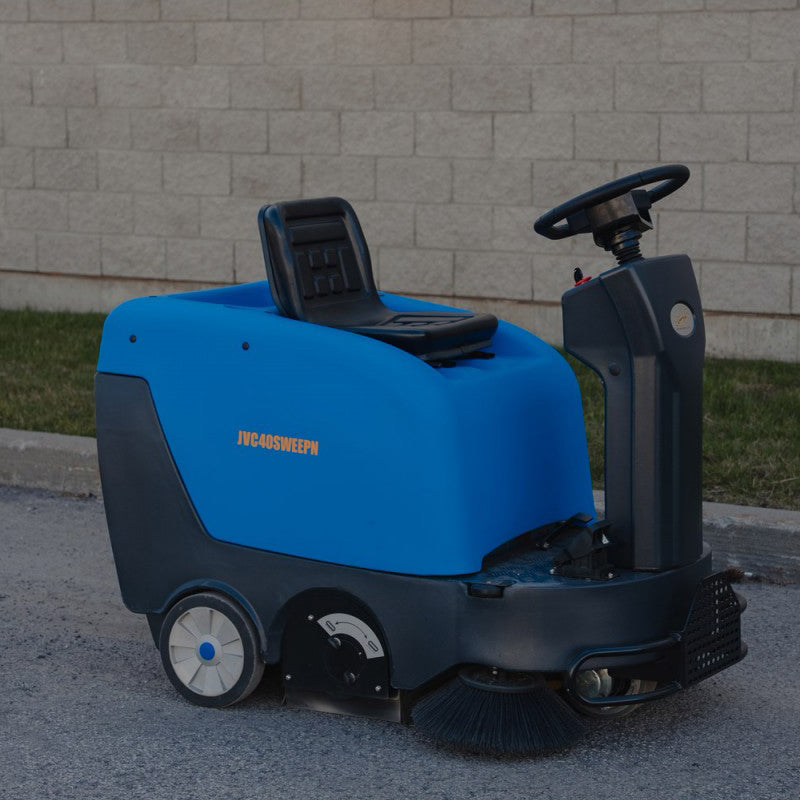Right-angled view of Johnny Vac Industrial Ride-On Sweeper Machine JVC40SWEEPN on the road