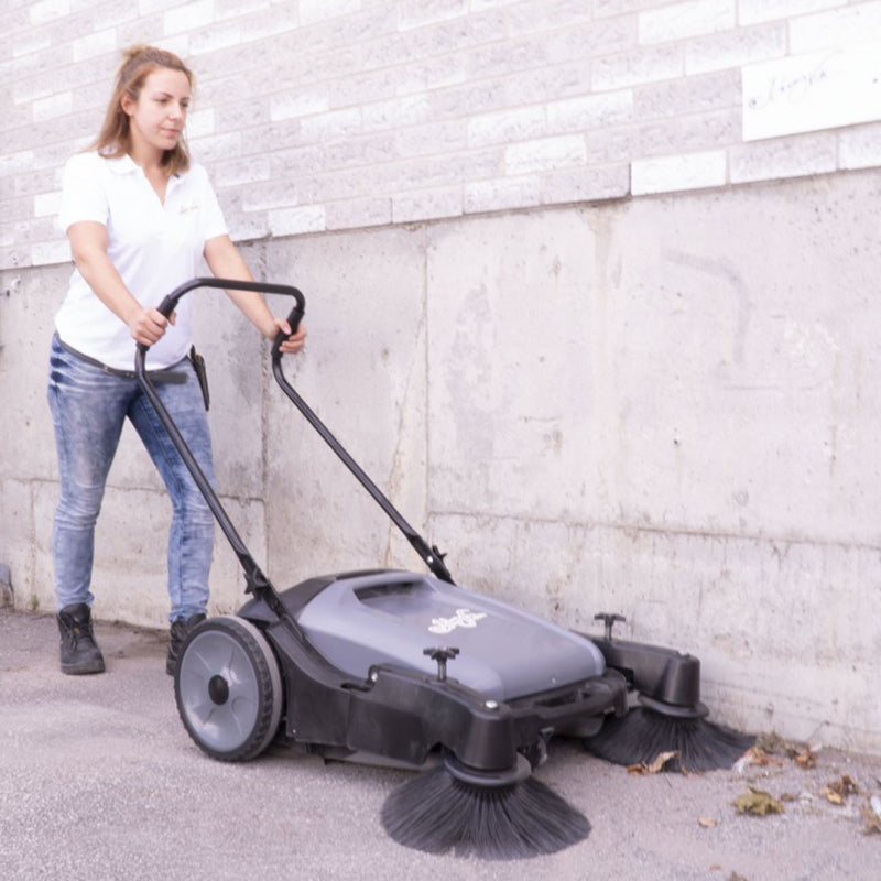 Worker cleaning road with Johnny Vac Manual Floor Sweeper JV320

